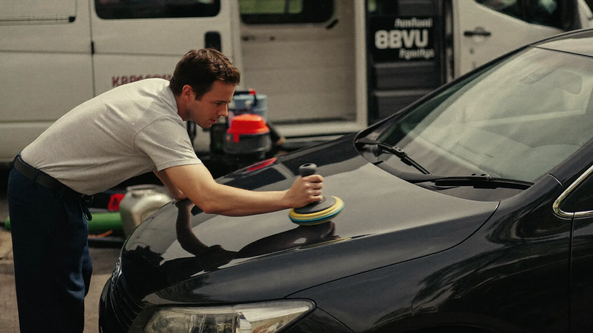 Auto detailer polishing the hood of a client's car