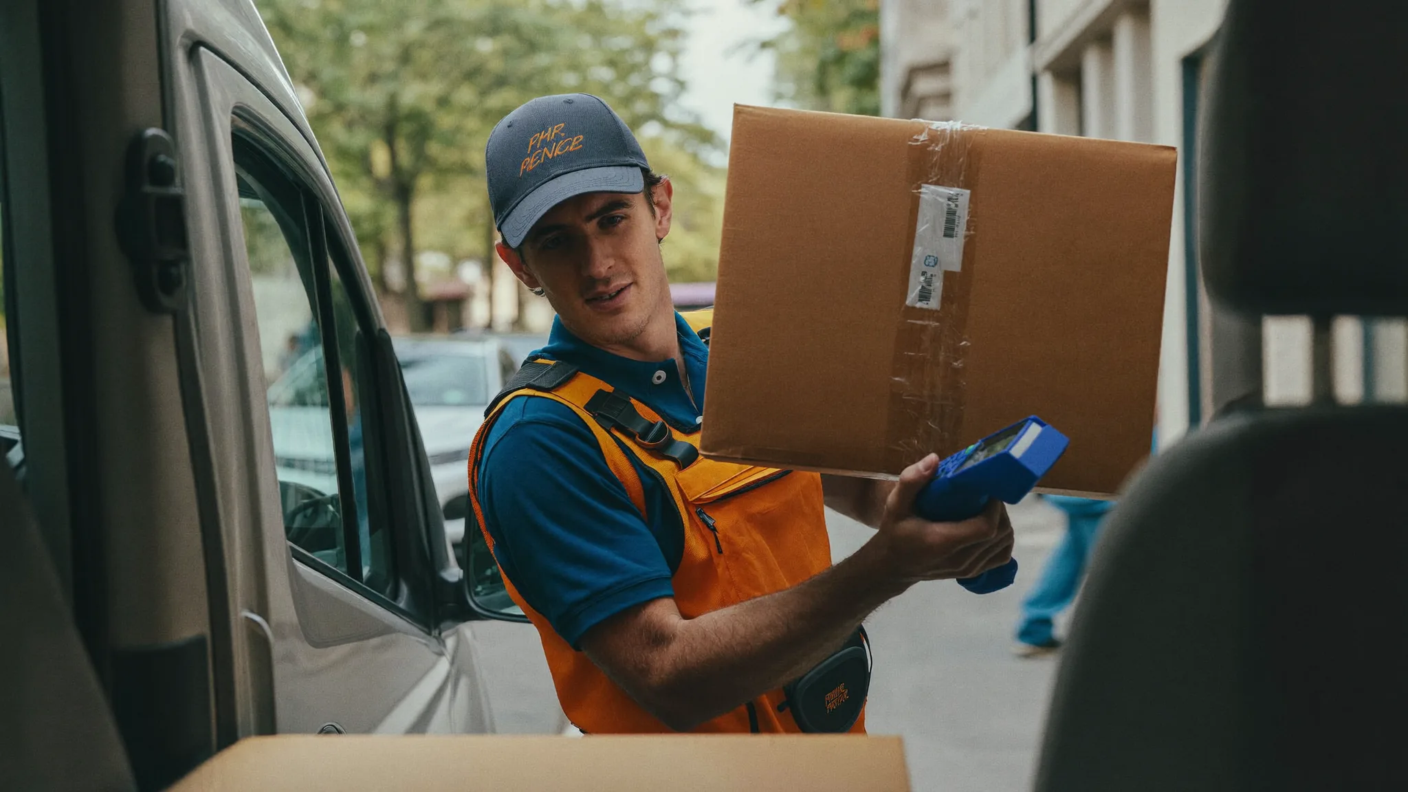 Courier carrying a package into an office building lobby