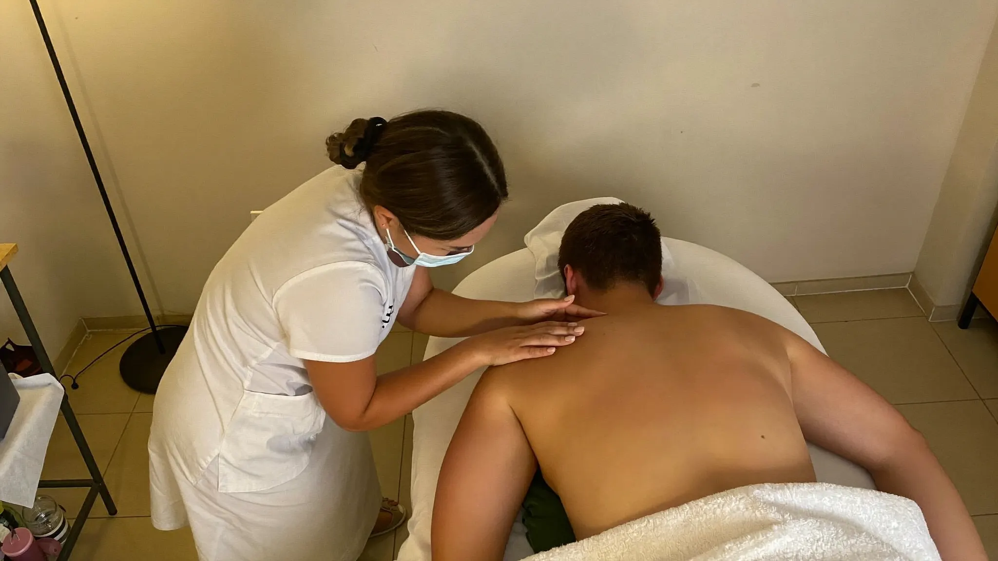Massage therapist working on a client's shoulders on a massage table