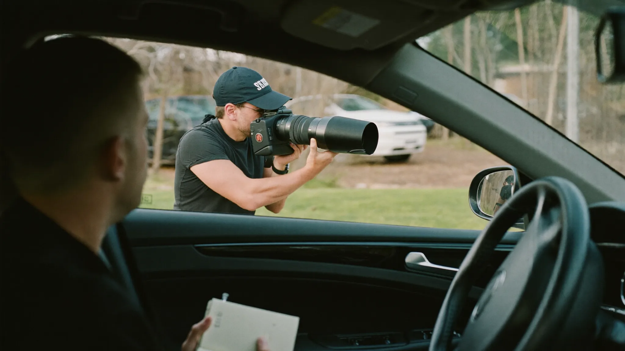 Private investigator reviewing surveillance photos and case notes at a desk