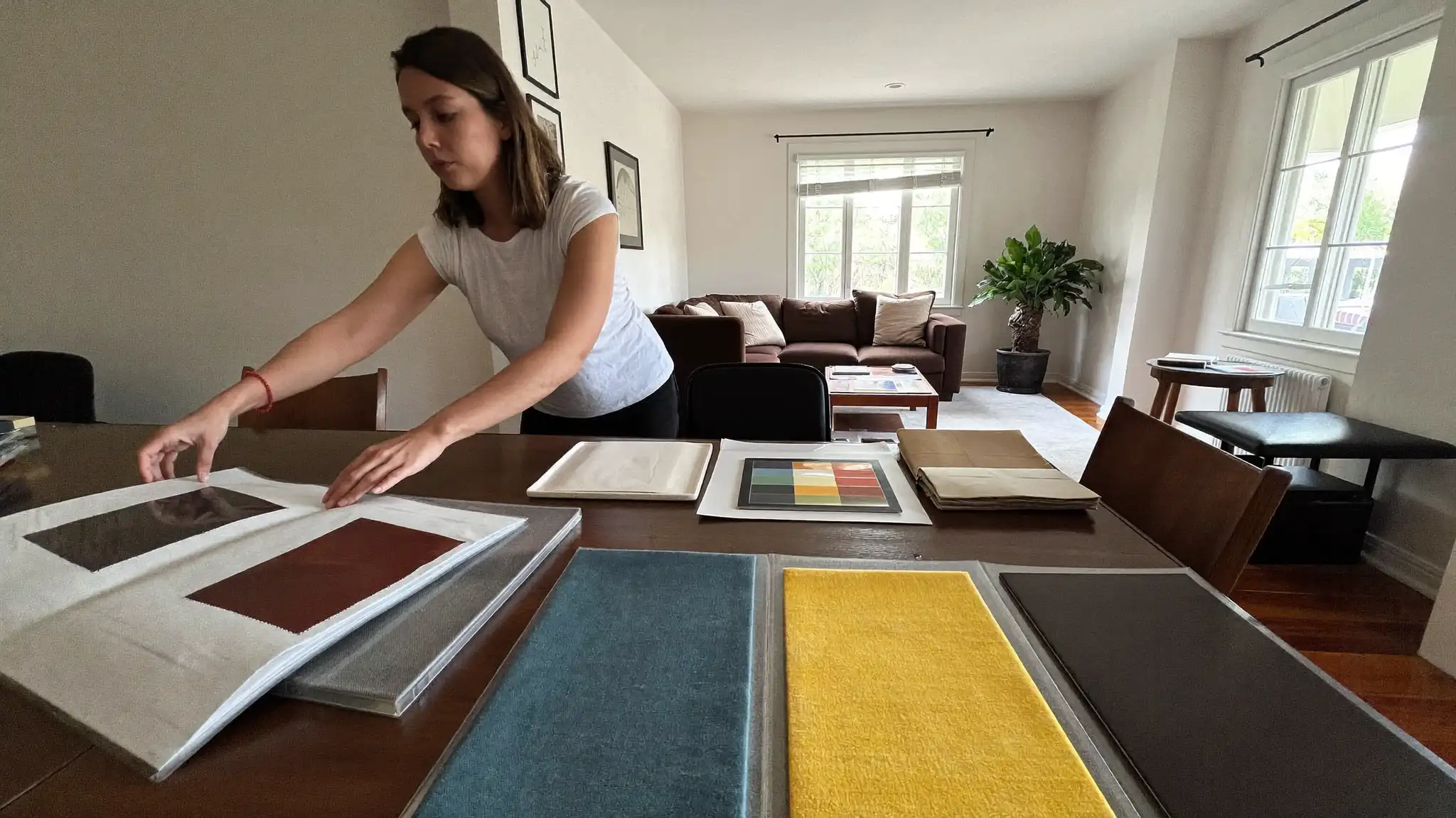 Interior designer arranging fabric swatches and paint samples on a table