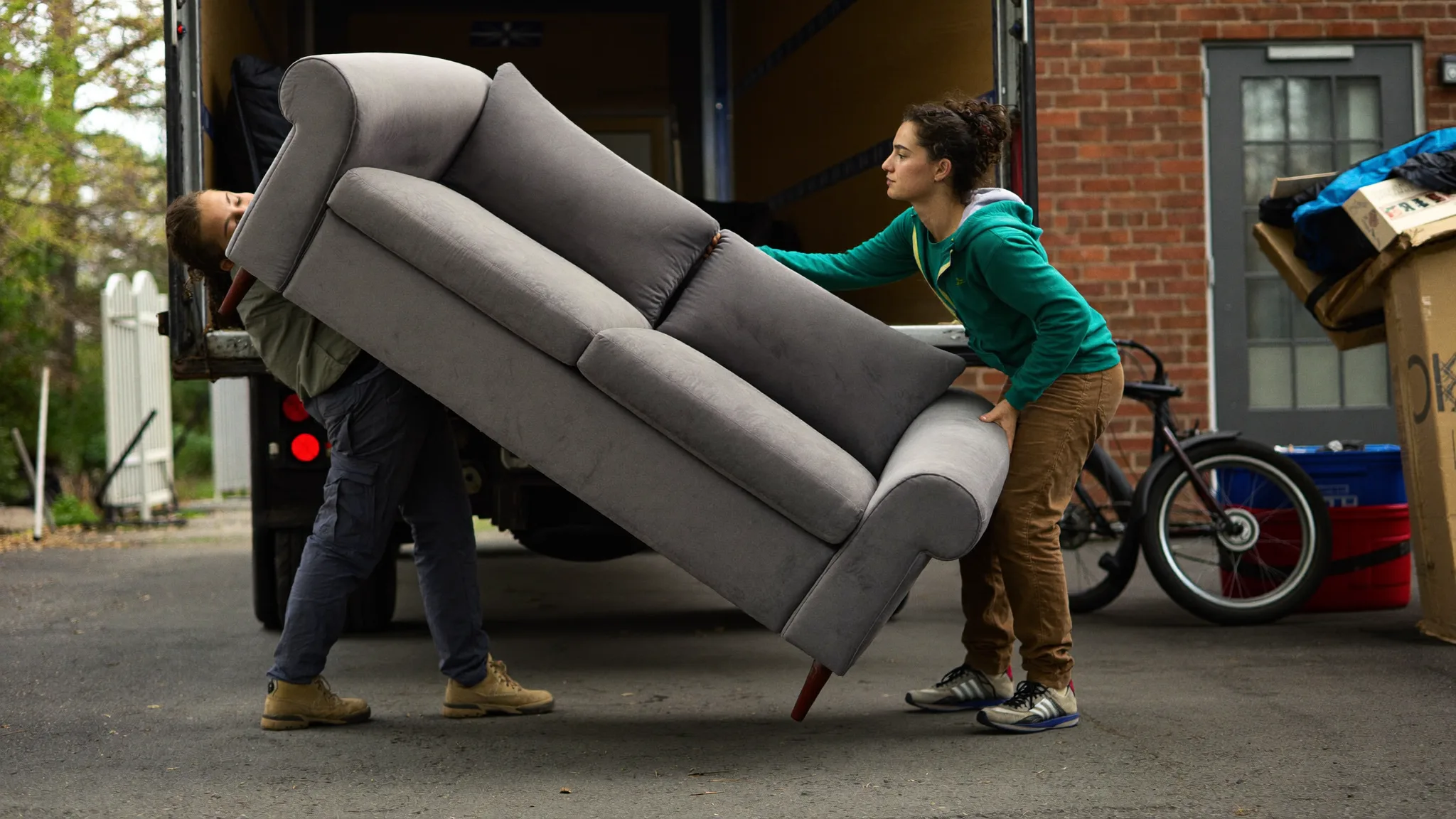 Junk removal crew hauling furniture out of a house into a truck