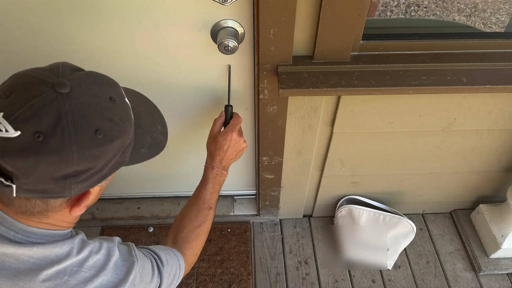Locksmith rekeying a deadbolt lock on a front door